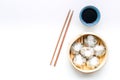 Dim sums with sticks and black tea in Chinese restaurant on white background top view mockup Royalty Free Stock Photo