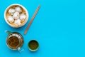 Dim sums with sticks and herbal tea in Chinese restaurant on blue background top view mockup Royalty Free Stock Photo