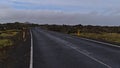 Winding country road with markings between moss covered lava fields of volcanic stones near Grindavik, Reykjanes, Iceland.