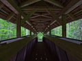 Diminishing symmetrical perspective of the interior of covered wooden footbridge crossing a river in Wutach Gorge.