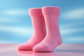 Diminutive socks against a rosy surface, poised for your affectionate missive