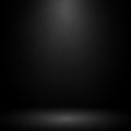 A dimly lit scene with a soft spotlight on a dark grey background. The central spotlight Royalty Free Stock Photo