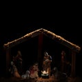 Dimly lit stable showing the Christian nativity scene with the baby Jesus glowing in light. Blank space above for text