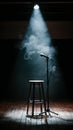 Dimly lit stage Spotlight on stool, microphone stand, hazy smoke creates intimate ambiance