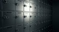 A dimly lit wall of metallic lockboxes features rows of secure compartments, each with Royalty Free Stock Photo