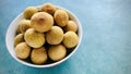 Longan in white bowl on green background. Royalty Free Stock Photo