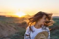 Dinamic shot woman with blowing hair on sunset in nature background, happy emotional girl