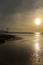 Dinas Dinlle beach with high tide markers at sunset.