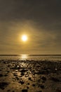 Dinas Dinlle beach with the sun setting reflected in the sea. Beach holiday concept