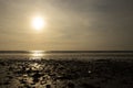 Dinas Dinlle beach with the sun setting reflected in the sea. Beach holiday concept