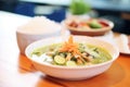 diner spooning green curry onto white rice