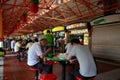 Diners eat at outdoor tables Maxwell Food Center Singapore