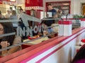 Diners eating at In-N-Out Burger location behind logo on glass divider