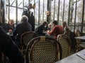Diners fill tables in glass-walled cafe on the grounds of Versailles Palace, France