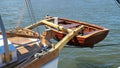 Dinghy, small rowing boat, made of mahogany wood, attached to the stern of a vintage sailing yacht. Schleswig-Holstein, Germany