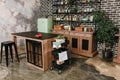 Dining area in industrial style with table, chairs and mint retro fridge. Black vintage brick wall background