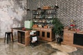 Dining area in industrial style with table, chairs and mint retro fridge. Black vintage brick wall background