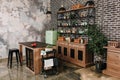 Dining area in industrial style with table, chairs and mint retro fridge. Black vintage brick wall background