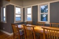 Dining area with wood table and chairs and view windows in contemporary upscale home interior