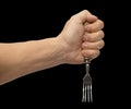 Dining fork in hand on a black background Royalty Free Stock Photo