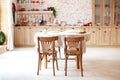 Dining room in a cottage style. brown kitchen with a round rustic dining table with chairs. Outdoor dining room interior with kitc