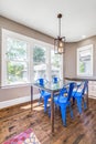 A dining room with a glass table and blue chairs.