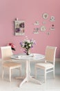 Dining room interior with flowers decorative plates pink wall an Royalty Free Stock Photo