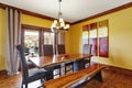 Dining room interior. Rustic wooden table, bench and high-back chairs. Royalty Free Stock Photo