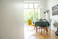 Dining room interior with wooden furniture,white walls, copy space and wide open glass door to balcony Royalty Free Stock Photo