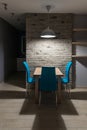 Dining room with wooden table illuminated with hanging above lamp