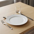 Dining setup on a light wood table. A plain white ceramic plate is centrally placed, Royalty Free Stock Photo