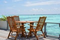 Dining setup with wooden tables and chairs at the restaurant near the ocean Royalty Free Stock Photo