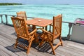 Dining setup with wooden tables and chairs at the restaurant near the ocean at resort Royalty Free Stock Photo