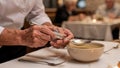 Dining staff helping senior hold adaptive spoon for soup capturing focused hands and utensil with softfocused dining Royalty Free Stock Photo