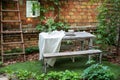 Dining table in backyard at home. Cozy space in patio or balcony. Terrace outdoor with brick wall and plants, table and wooden be Royalty Free Stock Photo