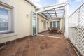 Dining table and chairs in part of the covered terrace of a large urban terrace Royalty Free Stock Photo