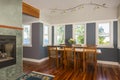 Dining table and chairs with wood floors, painted walls, accent lighting and view windows in contemporary upscale home interior