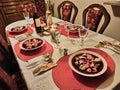 A dining table containing christmas eve lunch with food consists of Borscht beetroot soup with cabbage dumplings with wine bottles Royalty Free Stock Photo