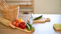 Dining table with fresh vegetables, chopping board, knife and cooking appliances Royalty Free Stock Photo