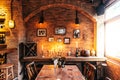 Dining table of Italian restaurant decorated with brick and photo frames in warm light that created cozy atmosphere Royalty Free Stock Photo