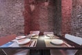 Dining table of a restaurant in a basement with rigid bricks arranged for the service