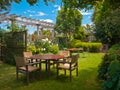 Dining table set in lush garden Royalty Free Stock Photo