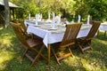 Dining table set in lush garden Royalty Free Stock Photo