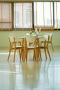 Dining table with set in modern home, White sunlight shines through the Venetian curtains on the windows Royalty Free Stock Photo