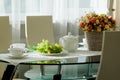 Dining table set up with crockery for tea, grapes, flowers Royalty Free Stock Photo