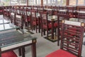 Dining table set up indoor with empty wooden chairs and glass tables, prepared for an event Royalty Free Stock Photo