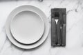 Dining table setting. Two grey plates with silver cutlery on the linen napkin Royalty Free Stock Photo