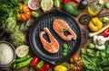 Dinner cooking ingredints. Raw uncooked salmon fish with vegetables, rice, herbs, spices and oil in iron grilling pan Royalty Free Stock Photo