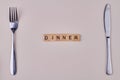 Dinner inscription on wooden blocks. Fork and knife on white background. Royalty Free Stock Photo