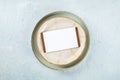 Dinner invitation. A card on a plate with a gold rim, overhead flat lay shot